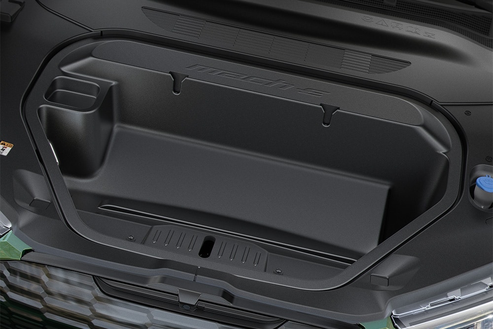 En person som plasserer en bag i frunken på en Ford Mustang Mach-E.