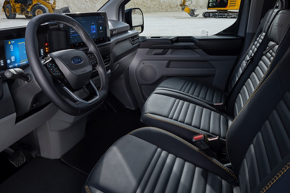 Interiør i en Ford Transit Custom Sport-varebil med sorte og gullfargede seter.
